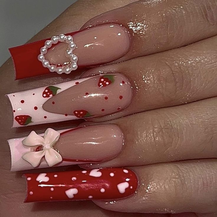 Strawberry-themed nail art with red and pink designs, featuring bows and hearts, creating a playful, elegant look.