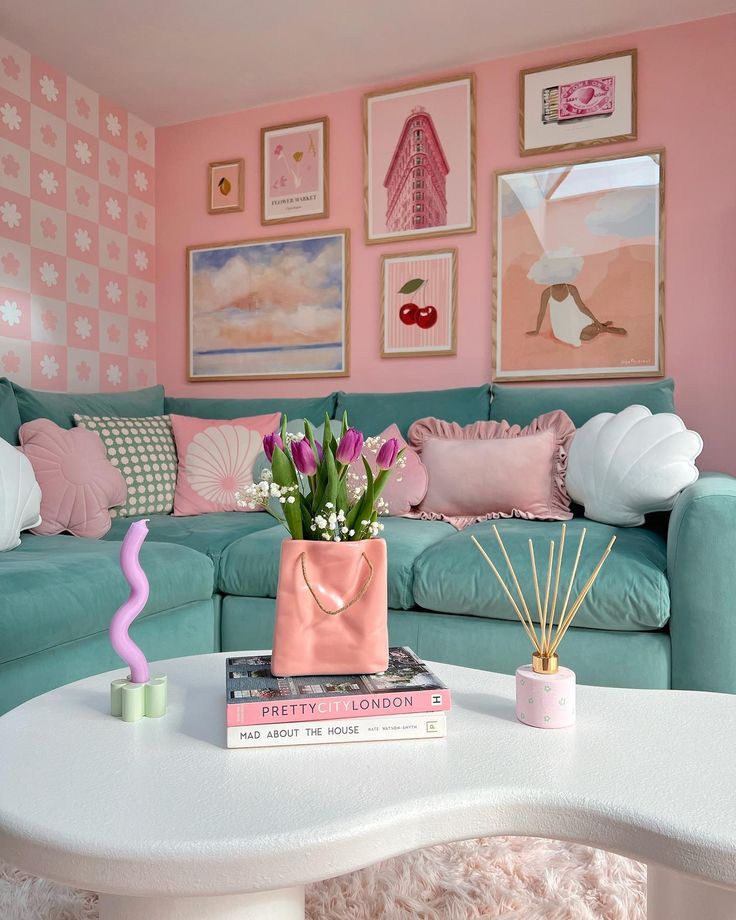 Chic pastel living room with teal sofa, pink wall art, and a white table featuring tulips and decorative books. Cozy and stylish decor.