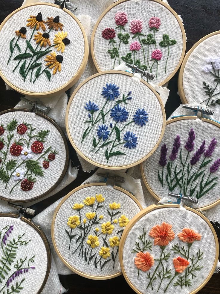 Colorful floral embroidery on hoops, featuring various flower designs. Perfect for craft inspiration and handmade décor.