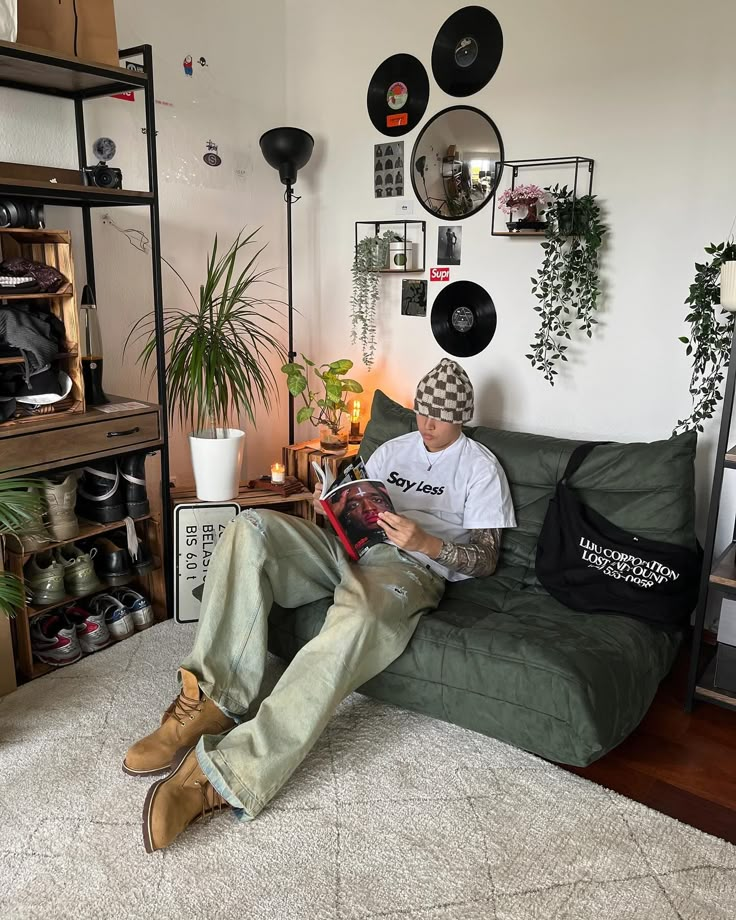 Cozy room with plants and records; person reading on a sofa, wearing a casual outfit with boots and a beanie.