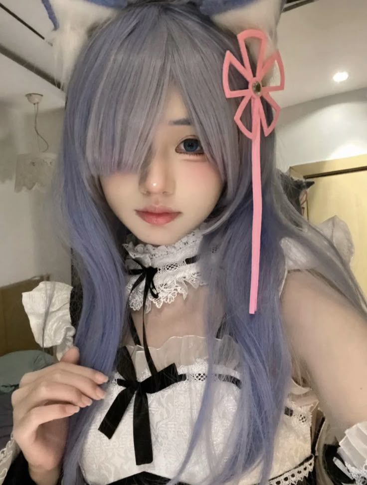 Young woman in anime-style purple hair and cat ears cosplay with lace dress and pink bow accessory.