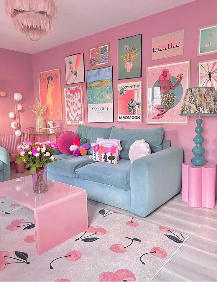 Vibrant pink-themed living room with art gallery wall, pastel blue sofa, and floral decor for a cozy, modern aesthetic.