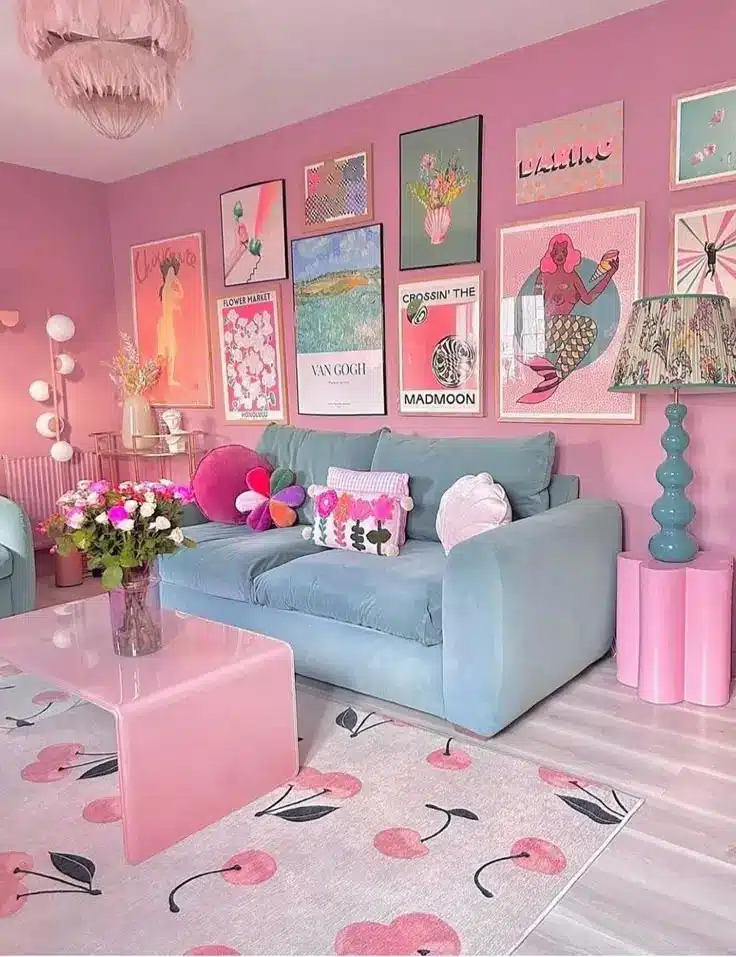 Vibrant pink-themed living room with art gallery wall, pastel blue sofa, and floral decor for a cozy, modern aesthetic.