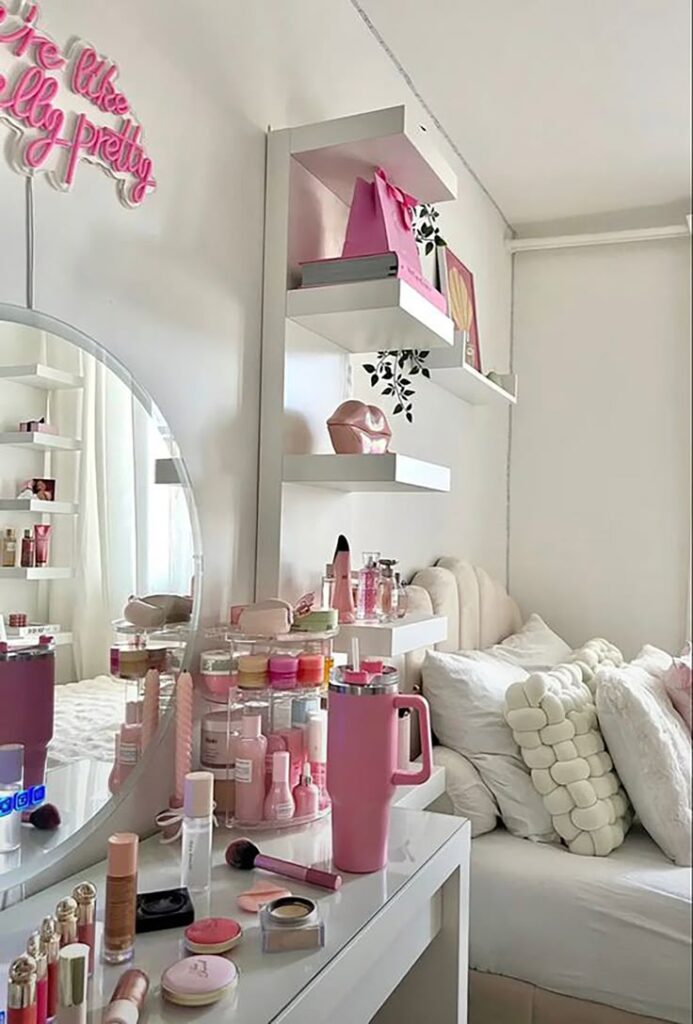 Chic vanity with makeup, pink accents, and modern decor in a cozy bedroom setting. Perfect blend of style and comfort.