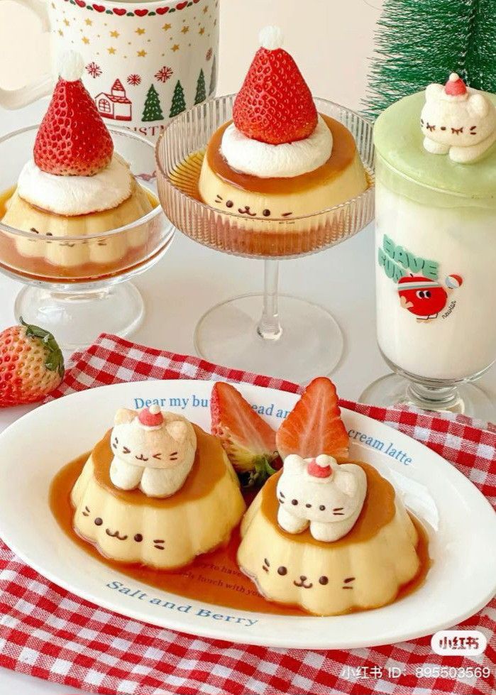 Festive cat-themed desserts with strawberries and cream, set on a checkered cloth; perfect for a cute Christmas treat display.