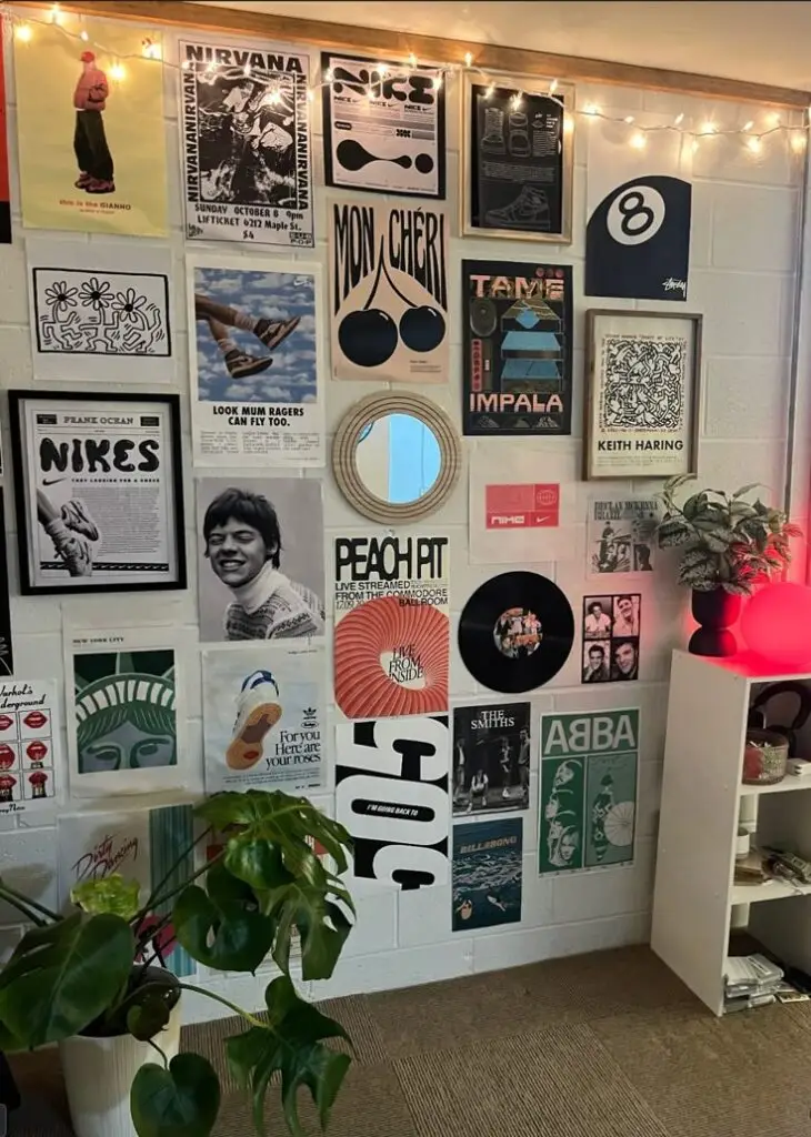 Stylish room with music and art posters, mirror, warm lighting, and a green plant creating a cozy, artistic vibe.