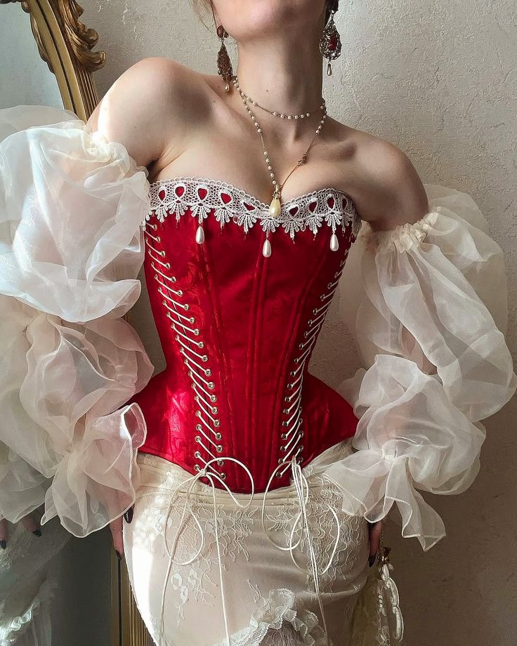 Victorian-inspired red corset with lace trim and billowy sheer sleeves, showcasing vintage fashion elegance.