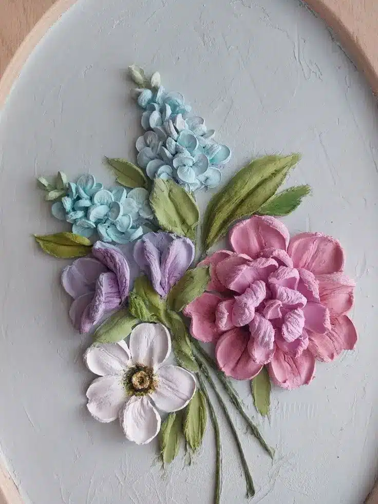 Colorful clay flowers on canvas: pink peony, purple iris, white daisy, and blue hyacinth. Perfect home decor art.