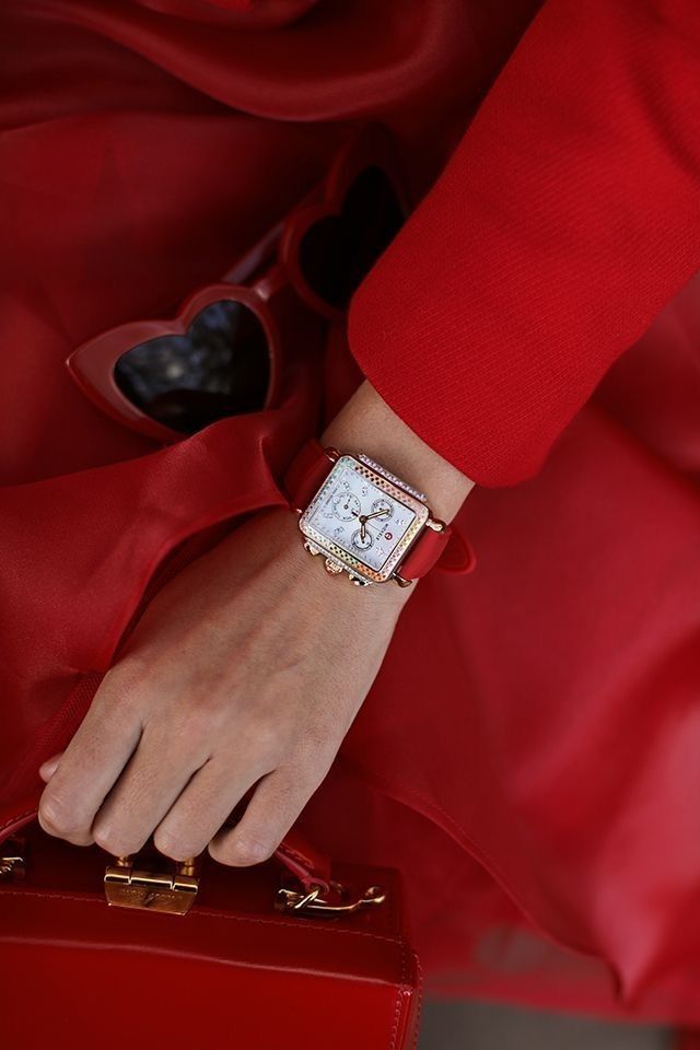 Elegant red outfit with heart-shaped sunglasses, luxury square watch, and handbag, showcasing chic fashion accessories.