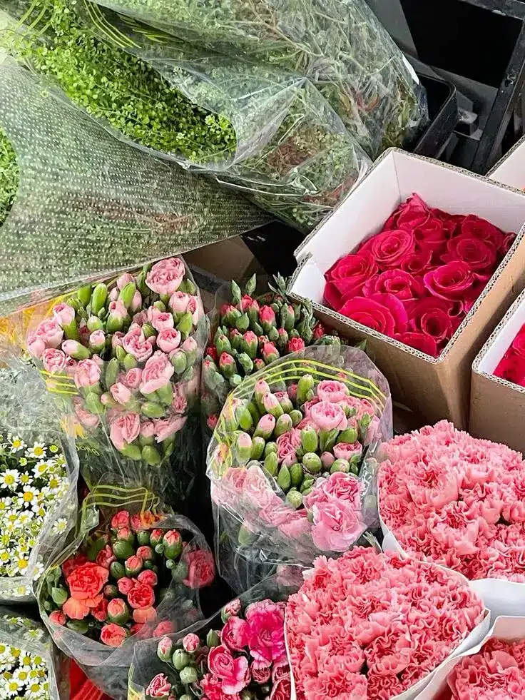 Fresh floral arrangement with pink roses, carnations, daisies, and greenery in packages, perfect for celebrations.