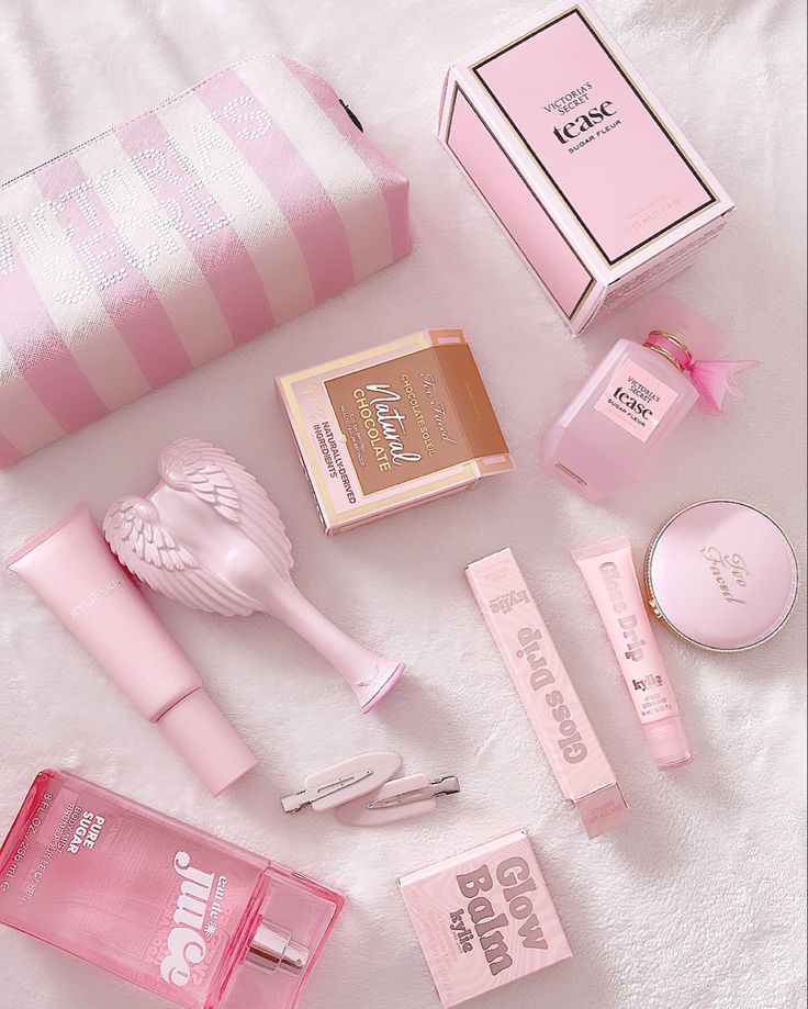 Pink-themed beauty products and accessories arranged aesthetically on a soft background, featuring perfumes, creams, and cosmetics.