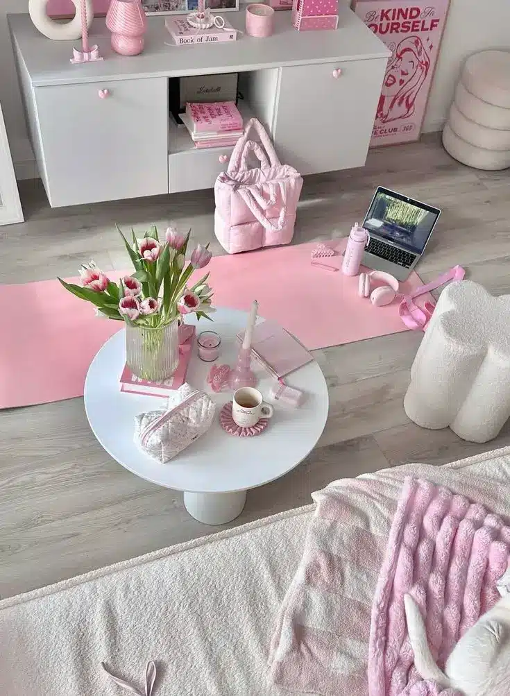 Cozy pink-themed room with tulips, a laptop, and decor. Perfect for relaxing or working from home.
