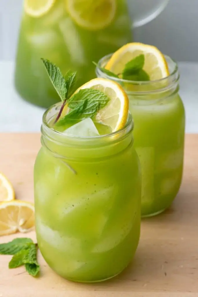 Refreshing mint lemonade in mason jars with lemon slices and ice, perfect for a summer drink.