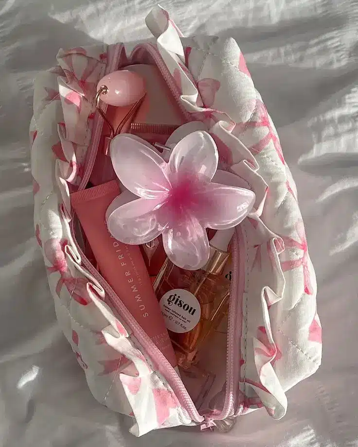 Floral makeup bag with pink essentials and a flower accessory. Perfect for a trendy, feminine look.