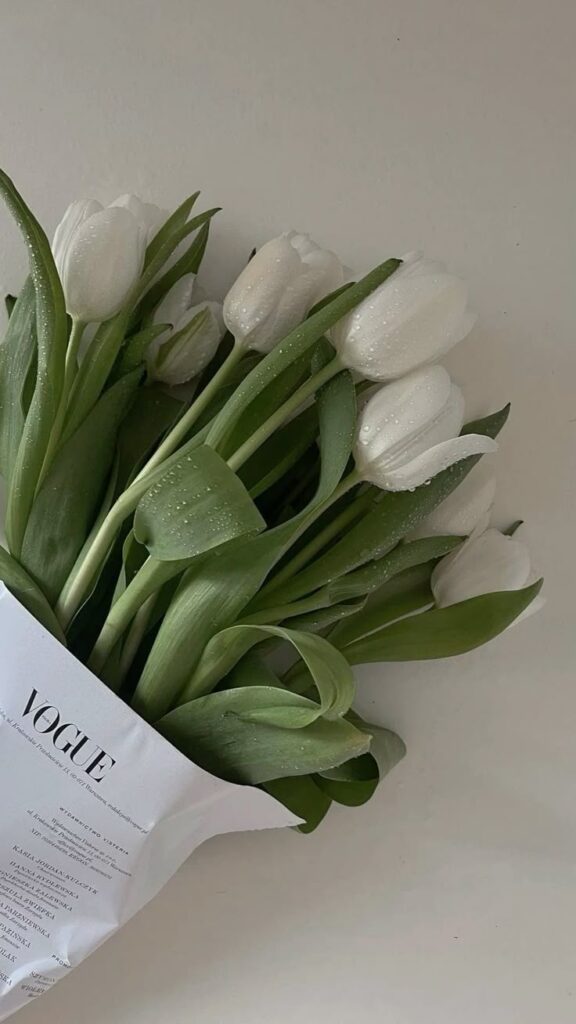 Elegant bouquet of white tulips wrapped in a Vogue-themed paper, ideal for adding a touch of sophistication to any setting.