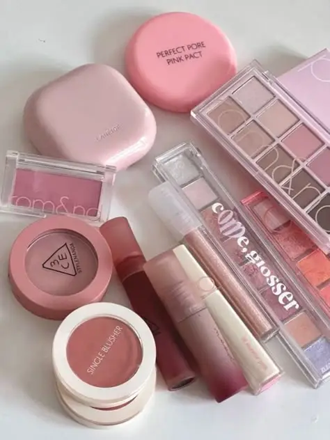18da0eb851125718da06e8d08d850baa - Handy Home Assorted pink makeup products including blushes, lip glosses, and eyeshadow palettes, perfect for a soft, feminine look.