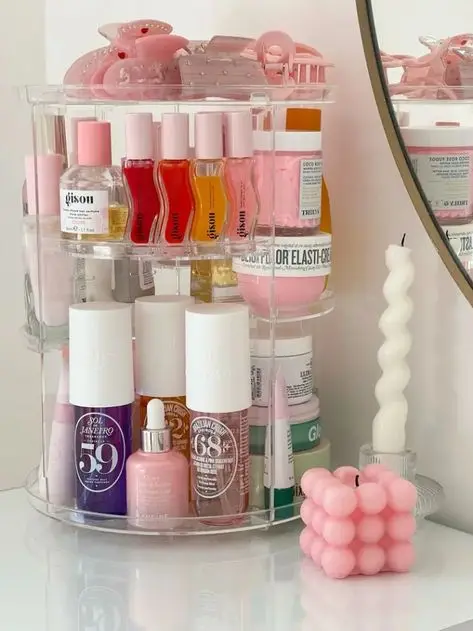 492b3c917fd59073288db79c6fa24767 - Handy Home Stylish makeup organizer with beauty products, pink and white candles on a pristine vanity. Modern and chic beauty setup.