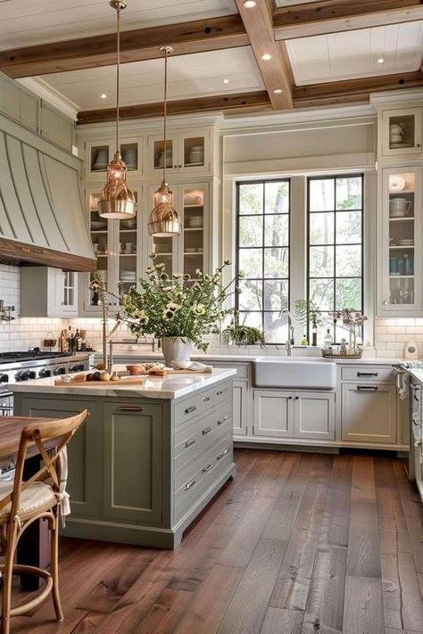 Spacious kitchen with green cabinets, wooden floors, copper pendant lights, and a large island. Elegant and modern design.