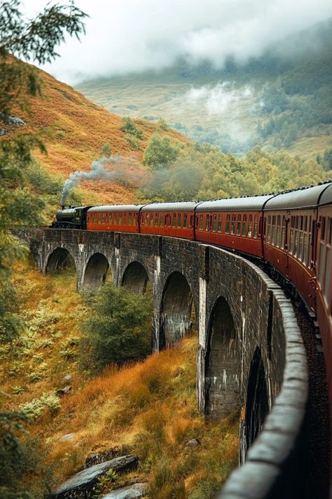 Steam train crossing a scenic viaduct in lush, misty Scottish landscape, autumn colors, travel, nature, adventure.
