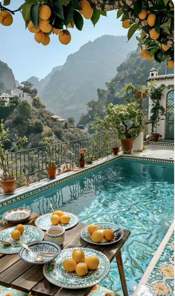 Sunny poolside oasis with citrus fruit decor, overlooking lush mountains and a serene valley in the background.