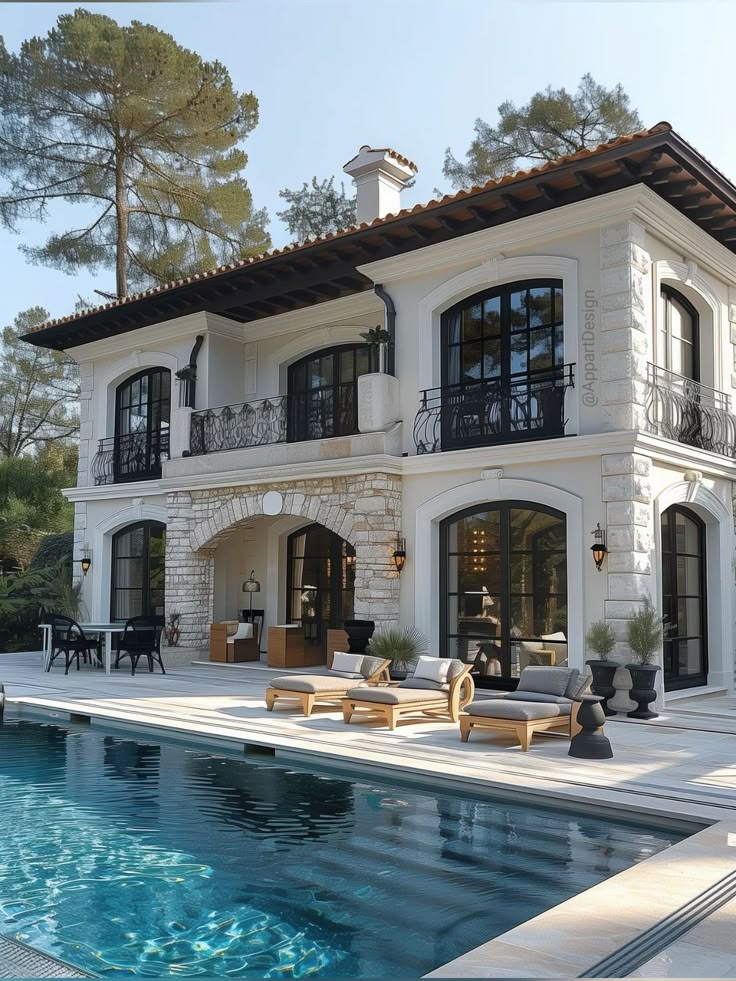 Luxury villa with elegant outdoor seating and a swimming pool, surrounded by nature and stone architecture.