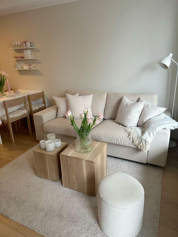 Modern living room with beige sofa, wooden tables, and tulip decor. Cozy dining area in soft tones, enhancing minimalist style.