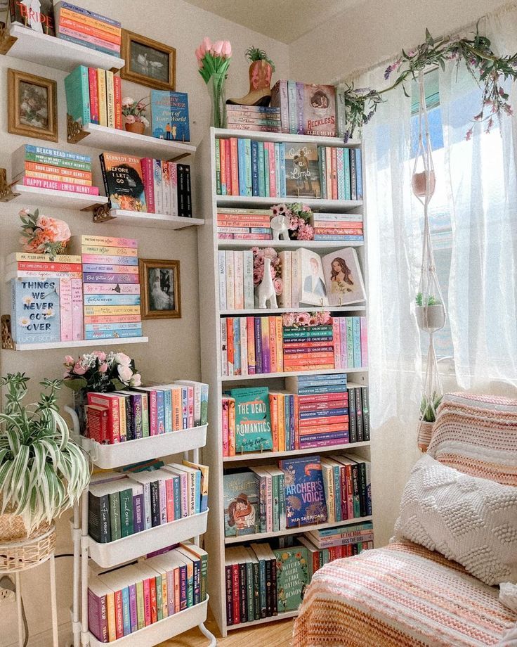 Cozy reading nook with colorful bookshelves, pastel decor, and natural light from a window with plants. Perfect book lover’s retreat.