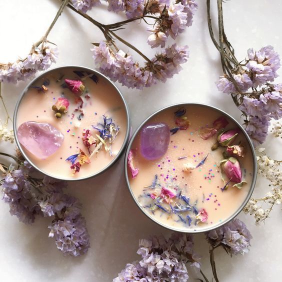 17 Candles That Smell So Amazing Youll Never Want to Leave Your Home - Handy Home Decorative candles with crystals and dried flowers, surrounded by lavender sprigs on a marble surface.