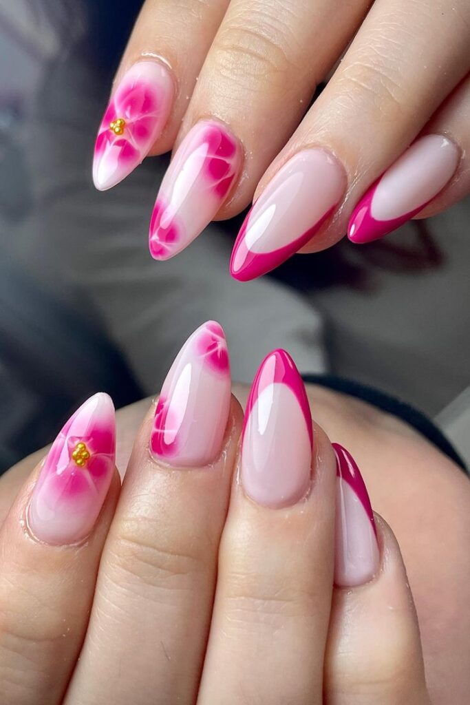 Elegant pink floral nail art with glossy finish, featuring detailed flower accents on stiletto-shaped nails.