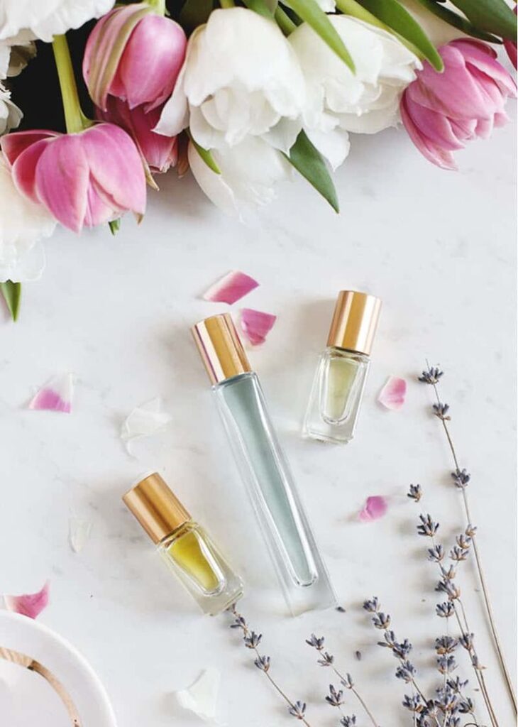 Essential oil bottles with lavender sprigs and tulip petals on a marble surface. Perfect for aromatherapy and relaxation.