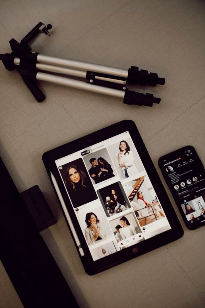 3e02858e-69a0-405f-bffe-0d0605ef4756 - Handy Home Tablet and smartphone showing social media apps, accompanied by a tripod, symbolizing digital content creation setup.