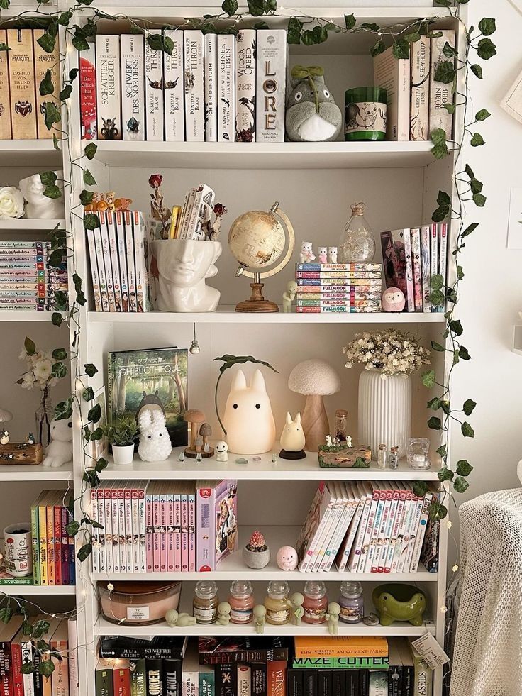 Cozy bookshelf with books, plush toys, and decor items, adorned with plants and fairy lights. Perfect reading nook inspiration.