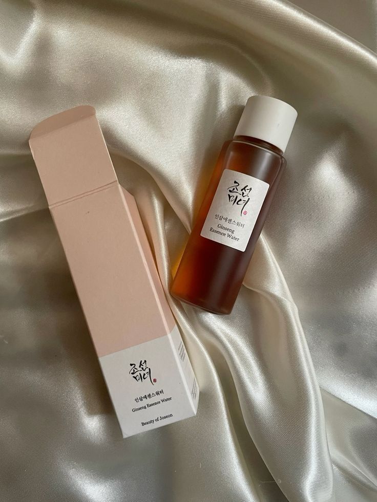 Korean skincare product Ginseng Essence Water on silky fabric, enhancing beauty and elegance. Perfect for nourishing skin care routine.