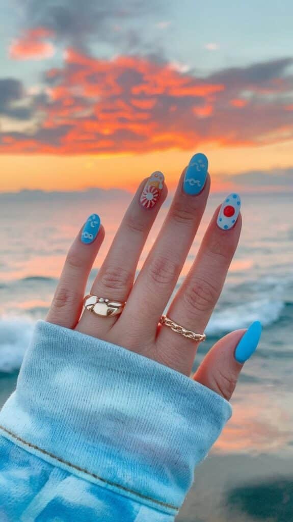 Colorful nail art with beach sunset backdrop, gold rings, and ocean waves for a serene vibe. Perfect summer aesthetic.