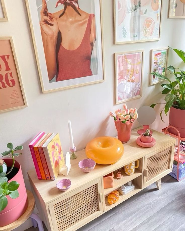 Stylish living room corner with colorful art, plants, and retro decor on a wooden sideboard, creating a cozy, vibrant atmosphere.
