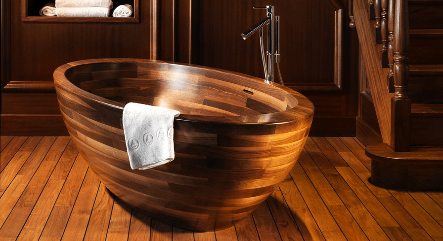 Luxurious wooden bathtub with towel in elegant bathroom setting, showcasing modern design and warm wood tones.