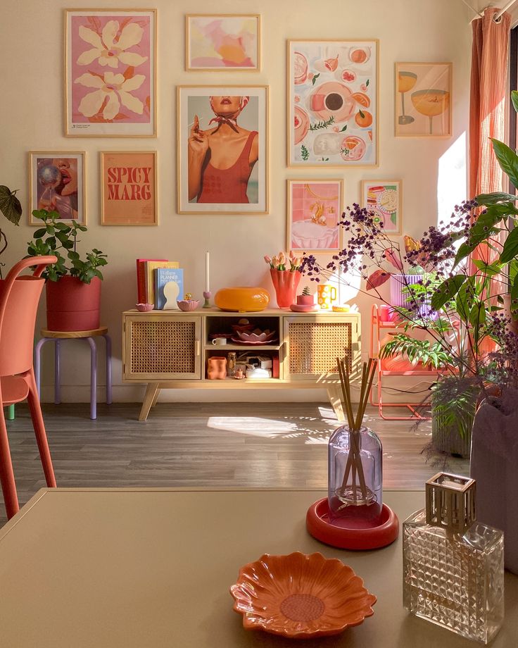 Colorful room with vibrant wall art, plants, and eclectic decor in warm tones of pink, orange, and yellow. Cozy and stylish.