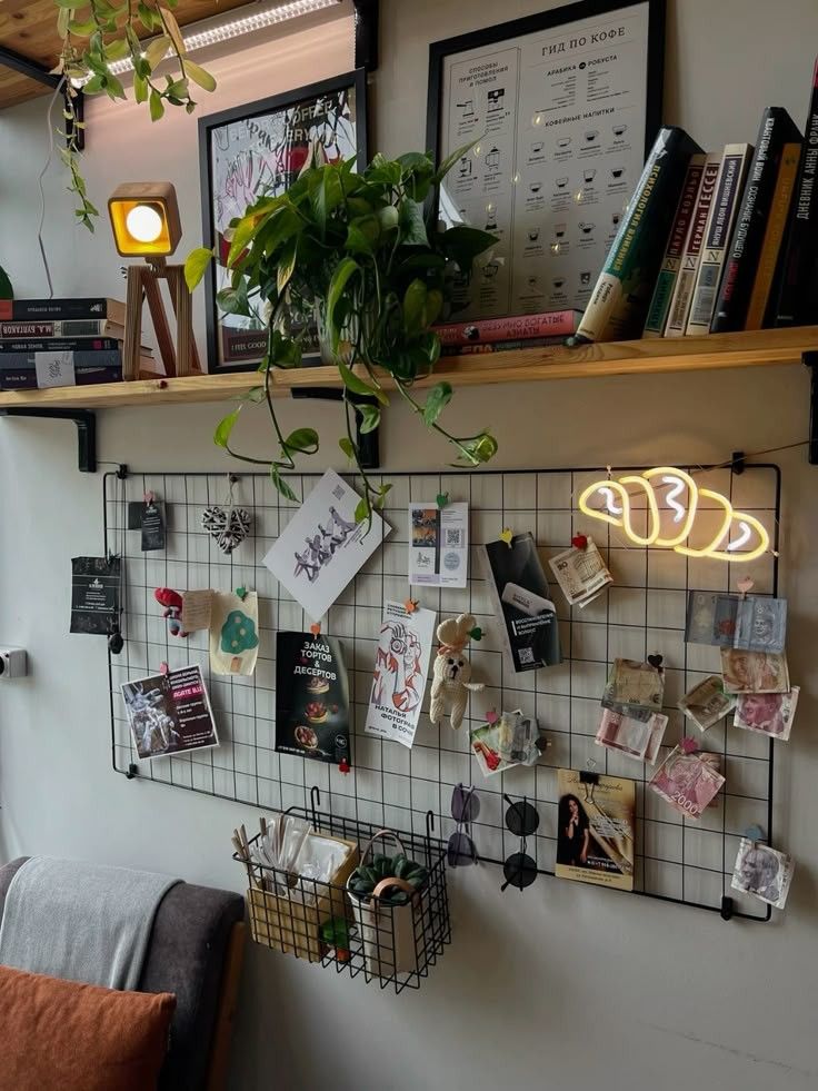 Creative workspace with bookshelf, plants, and a grid wall displaying art and photos. Cozy, organized, and inspiring ambiance.