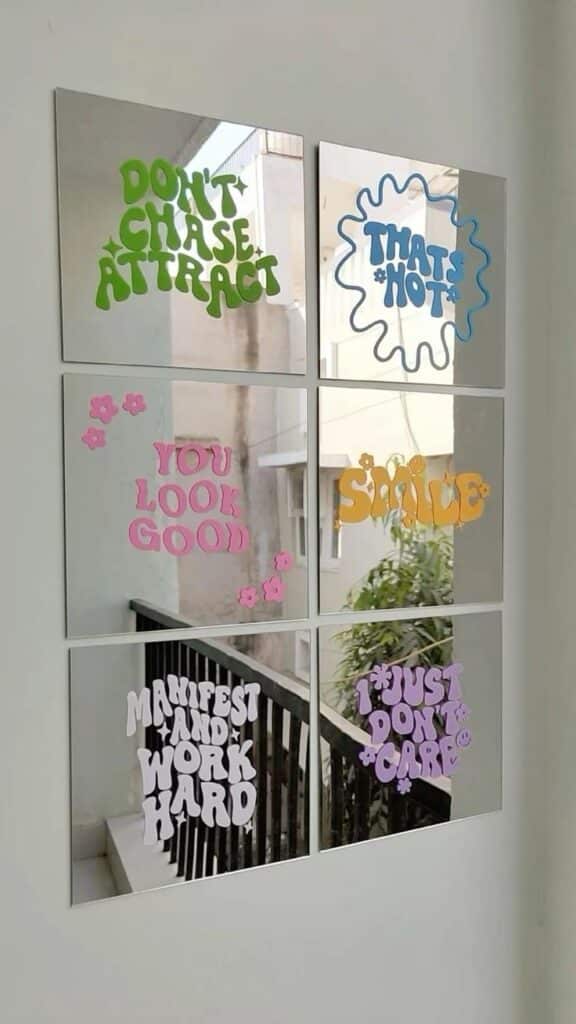 Mirrors with motivational phrases like Don't Chase, Attract and Smile in colorful fonts. Positive vibes decor.