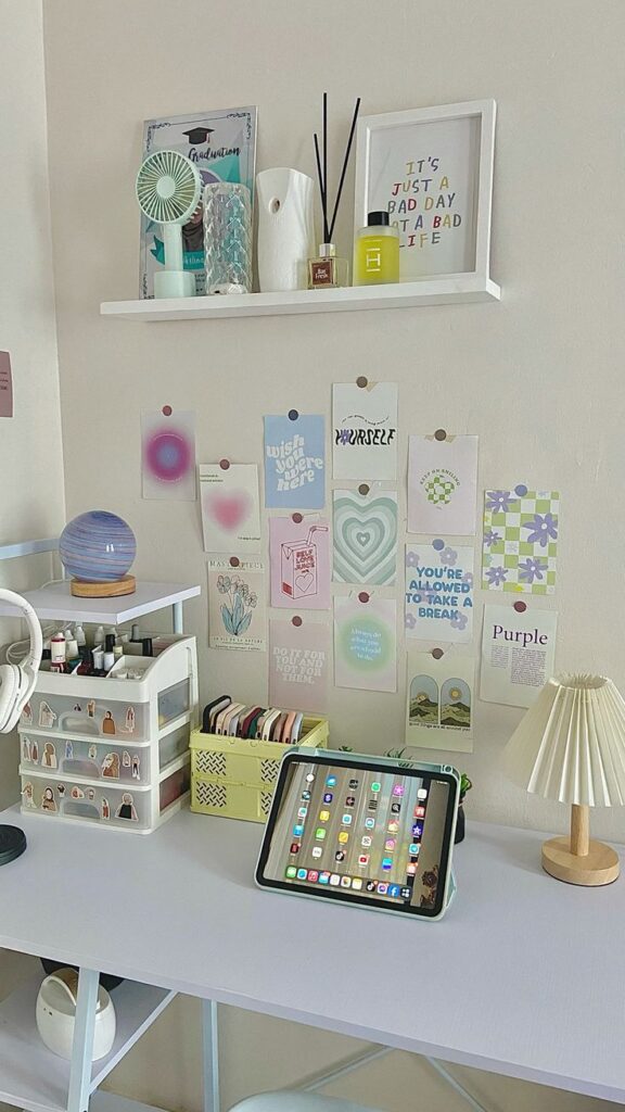 Cozy workspace with motivational wall art, shelves, an iPad on a desk, and desk organizer for an inspiring home office setup.