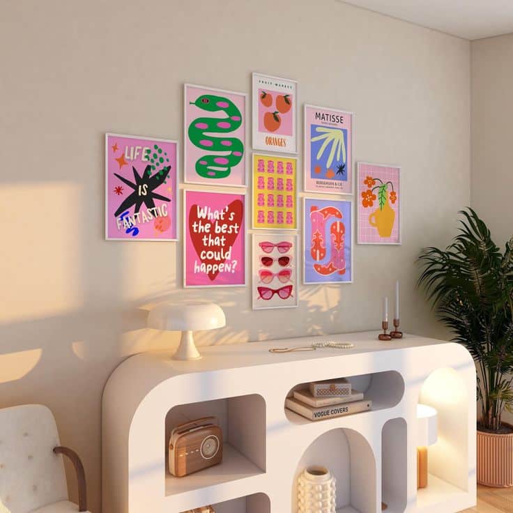 Colorful gallery wall with eclectic art prints above a modern white console in a cozy, well-lit living room with plants.