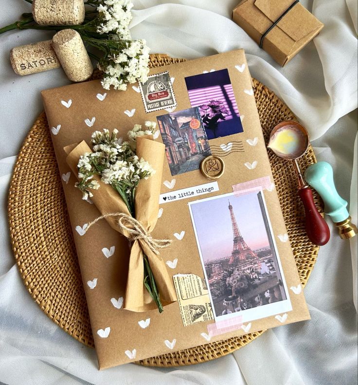 Decorative gift wrap with photos, flowers, and seals, featuring Paris scenes and vintage accents on a woven placemat.