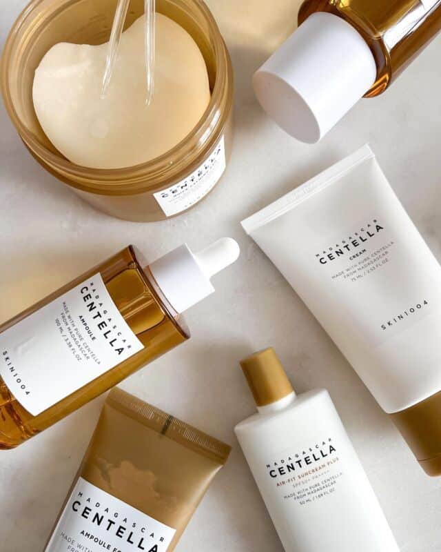 Assorted Madagascar Centella skincare products on a marble surface, including creams and serums from SKIN1004.