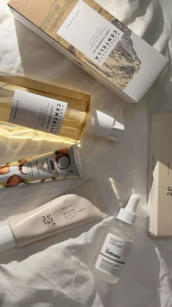 Assorted skincare products on a white cloth, featuring cleansers, serums, and creams for a glowing complexion.
