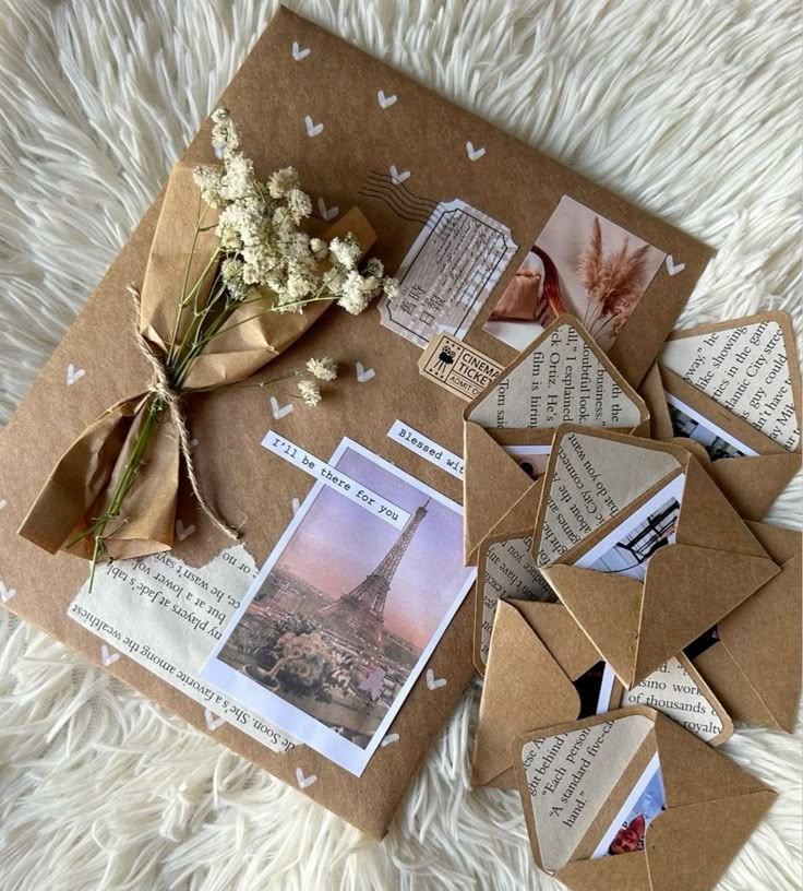 Vintage-themed envelope with dried flowers, Parisian postcard, and mini letters, styled on a cozy white fur background.