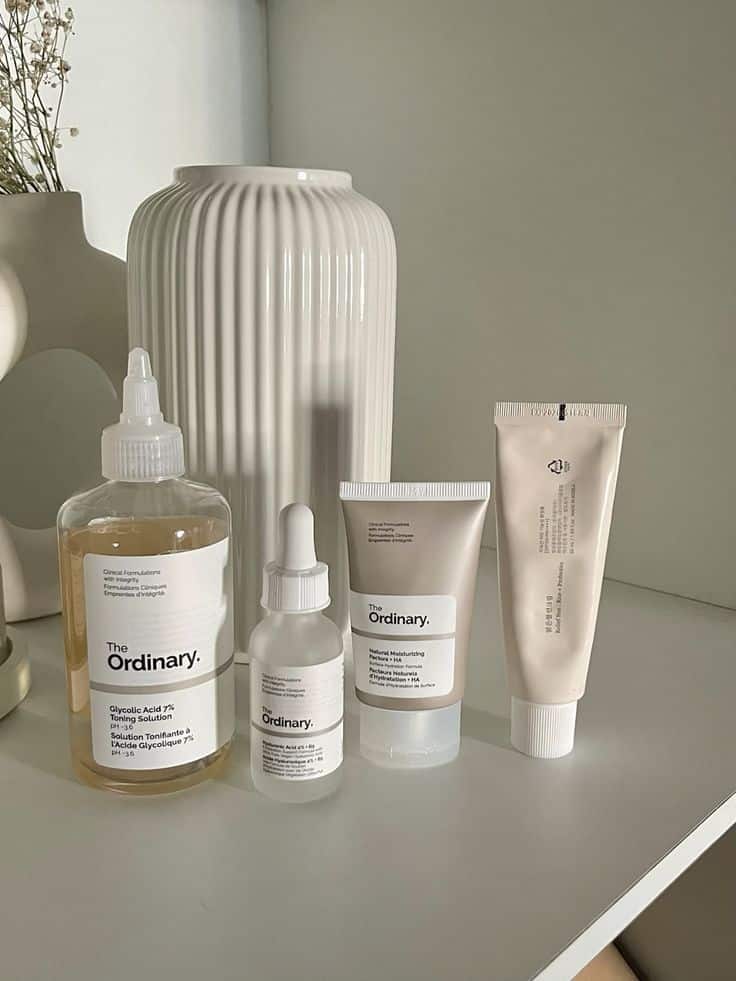 Minimalist setup with The Ordinary skincare products on a white shelf, featuring a sleek vase and soft lighting for a modern vibe.