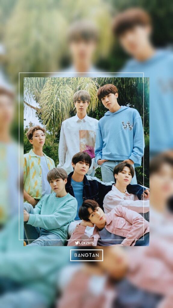 Group of young men posing outdoors in colorful casual clothing, surrounded by nature.