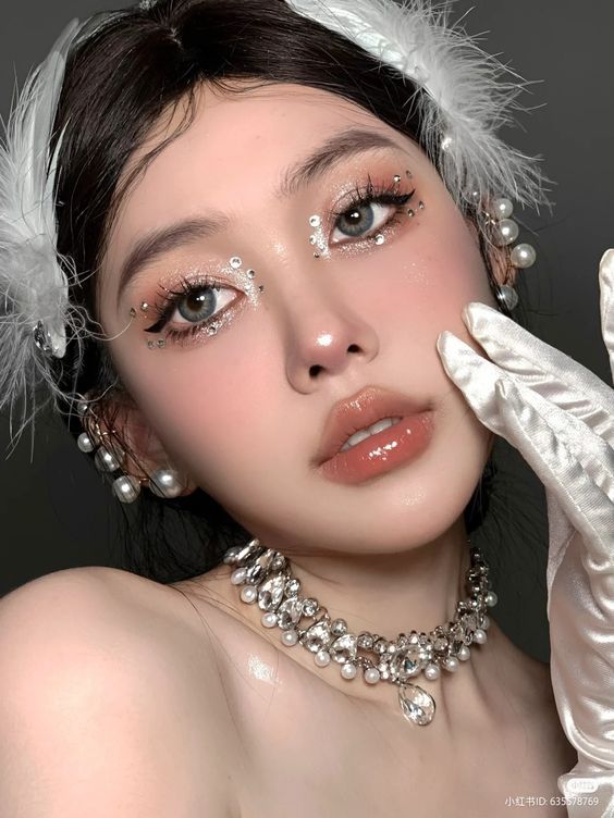 Elegant woman with crystal eye makeup, pearl jewelry, and white gloves, showcasing glamorous fashion and beauty style.