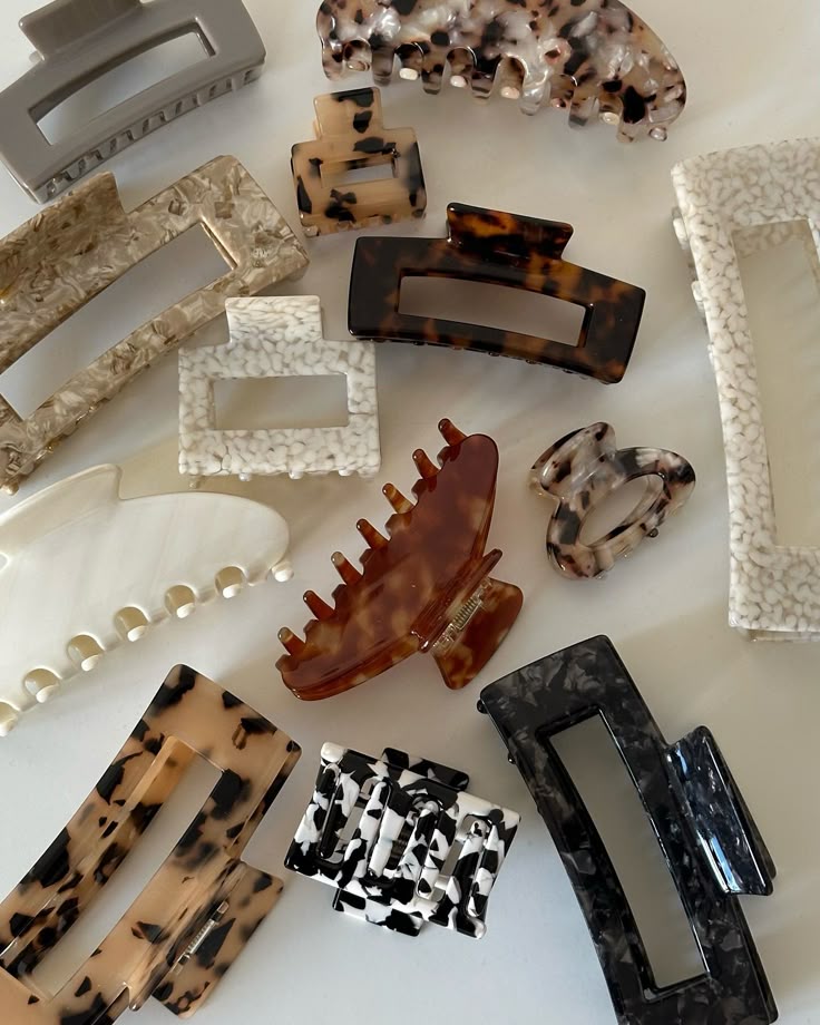 Assorted tortoiseshell and marble hair clips in various shapes, perfect for styling any hair type.
