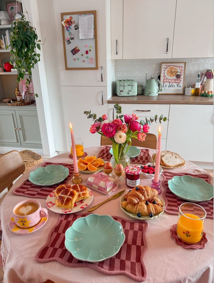 Cozy breakfast table with croissants, coffee, flowers, and candles in a bright kitchen setting. Perfect for a peaceful morning.